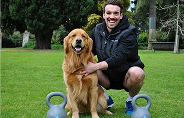 happy personal trainer with dog and kettlebells